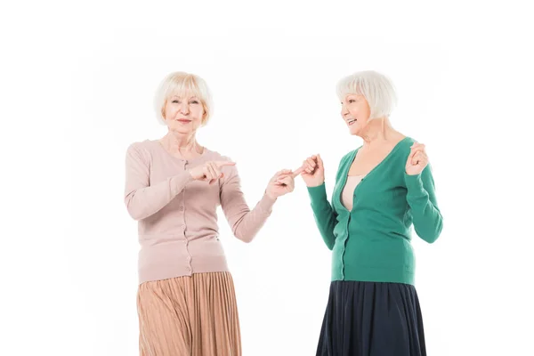 Senior élégant femme pointant par les doigts sur son ami isolé sur blanc — Photo de stock