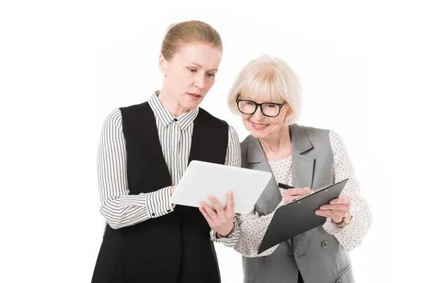 Дві стильні бізнес-леді з цифровим планшетом і буферами ізольовані на білому — стокове фото