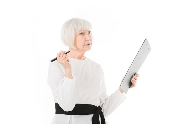 Femme d'affaires élégante senior debout avec presse-papiers et stylo isolé sur blanc — Photo de stock