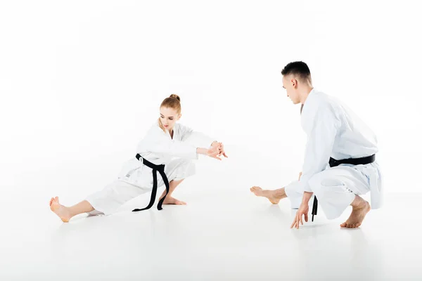 Karate fighters stretching legs isolated on white — Stock Photo