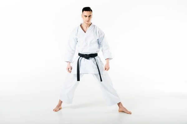Männlicher Karatekämpfer mit schwarzem Gürtel, stehend mit geschlossenen Augen isoliert auf weiß — Stockfoto