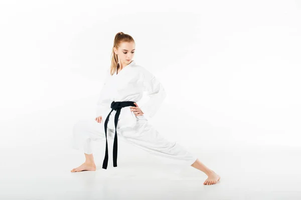 Karate-Kämpferin streckt Beine isoliert auf weiß — Stockfoto