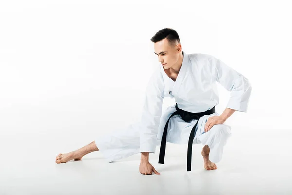 Male karate fighter stretching isolated on white — Stock Photo