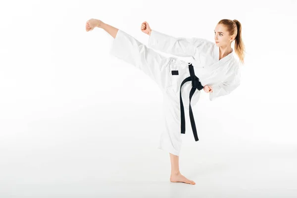 Karate-Kämpferin trainiert Kick isoliert auf Weiß — Stockfoto