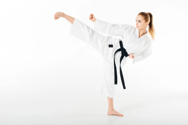 Kárate mujer entrenamiento patada aislado en blanco - foto de stock