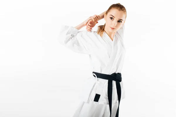 Karate-Kämpferin streckt die Schultern isoliert auf weiß — Stockfoto