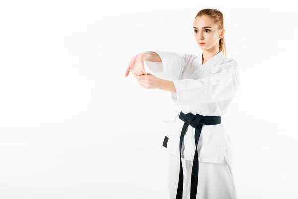 Female karate fighter stretching hands isolated on white — Stock Photo