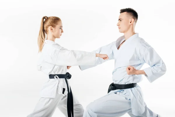 Vista lateral de los combatientes de karate ejerciendo en kimono aislado en blanco - foto de stock