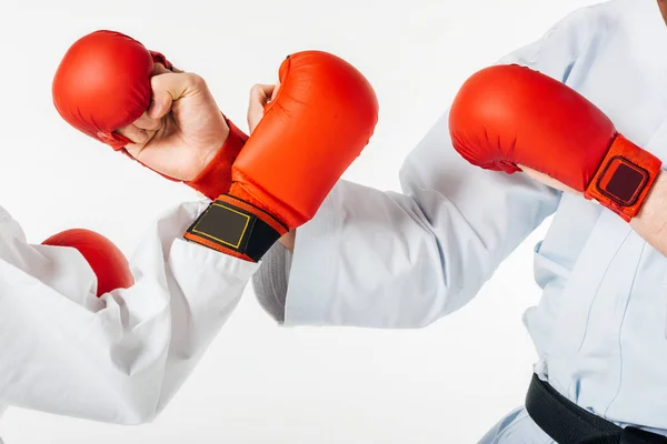 Обрезанное изображение бойцов карате, тренирующихся в перчатках, изолированных на белом — стоковое фото