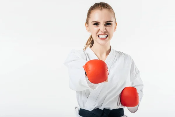 Luchadora de karate haciendo ejercicio con guantes y protector bucal aislados en blanco - foto de stock