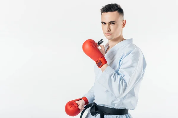 Combattente di karate maschio tenendo paradenti e guardando la fotocamera isolata su bianco — Foto stock