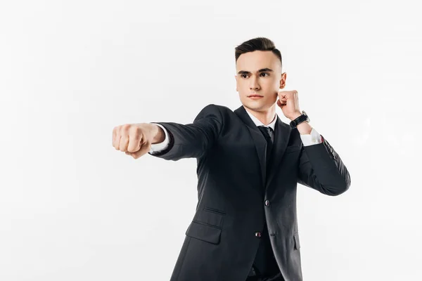 Hombre de negocios en traje realizando karate golpeado aislado en blanco - foto de stock