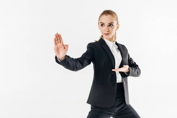 Femme d'affaires en costume debout en position de karaté et regardant loin isolé sur blanc — Photo de stock