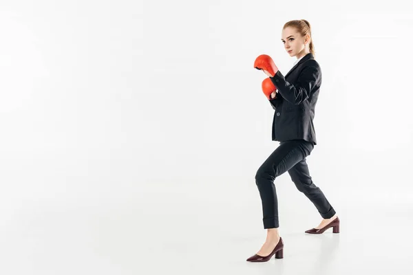 Vista lateral de mujer de negocios en traje y guantes rojos aislados en blanco - foto de stock