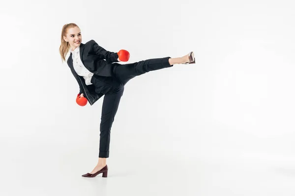 Mujer de negocios realizando patada en traje aislado en blanco - foto de stock