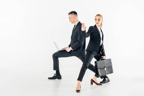 Empresarios en trajes con portátil y bolsa aislada en blanco - foto de stock