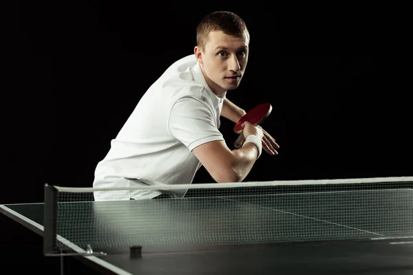 Joueur de tennis concentré jouant au tennis de table isolé sur noir — Photo de stock