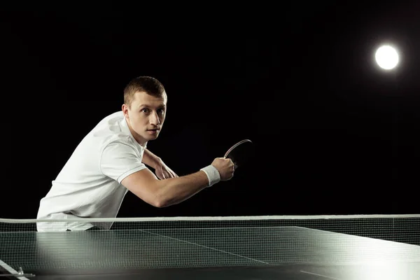 Portrait de jeune joueur de tennis jouant au tennis de table isolé sur noir — Photo de stock