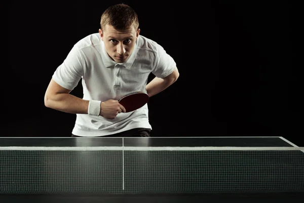 Joven tenista jugando tenis de mesa aislado en negro - foto de stock