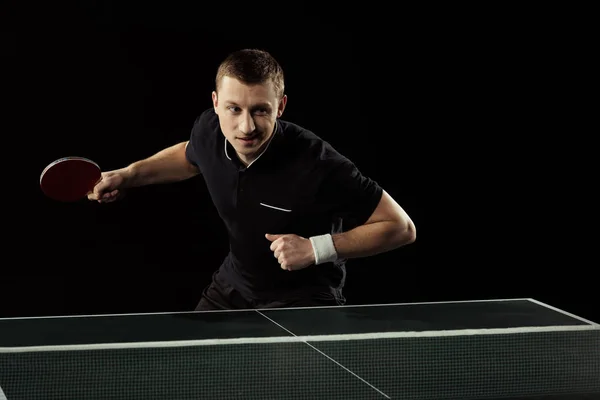 Ritratto di giovane tennista che gioca a ping pong isolato su nero — Foto stock