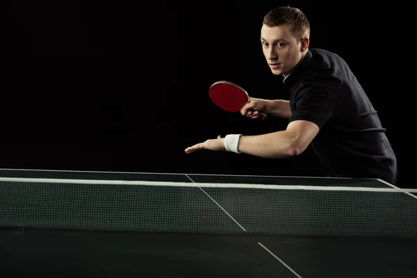 Ritratto di tennista concentrato che gioca a ping pong isolato sul nero — Foto stock