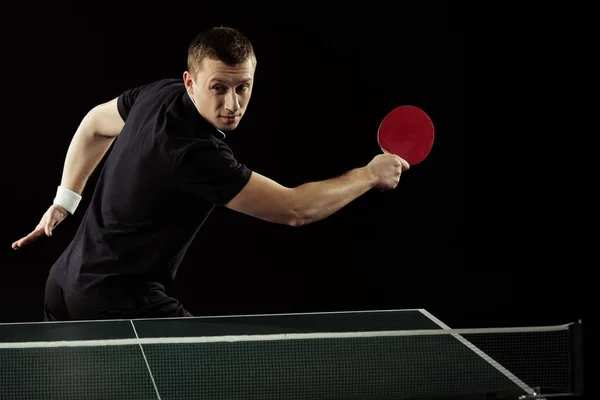 Portrait du joueur de tennis en uniforme jouant au tennis de table isolé sur noir — Photo de stock