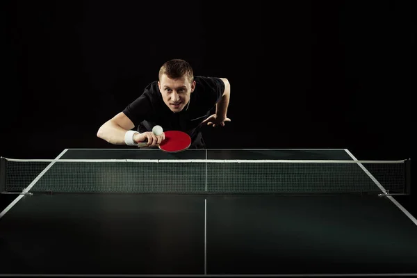 Portrait du joueur de tennis en uniforme jouant au tennis de table isolé sur noir — Photo de stock