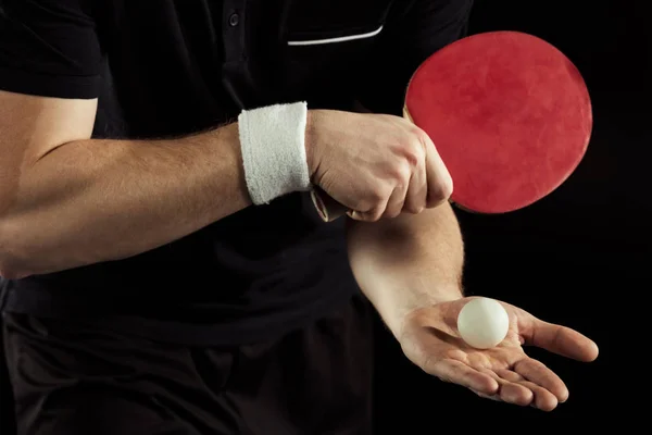 Cropped shot of tennis player with tennis ball and racket in hands isolated on black — Stock Photo