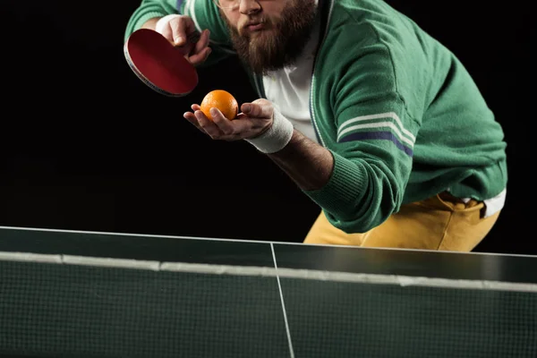 Vue partielle du joueur de tennis avec mandarine et raquette de tennis dans les mains isolées sur noir — Photo de stock