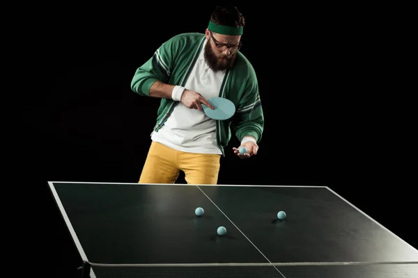 Joueur de tennis barbu pratiquant dans le tennis de table isolé sur noir — Photo de stock