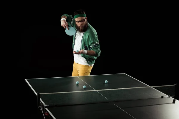 Joueur de tennis barbu pratiquant dans le tennis de table isolé sur noir — Photo de stock