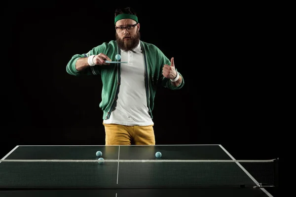 Bearded tennis player showing thumb up while practicing in tennis isolated on black — Stock Photo