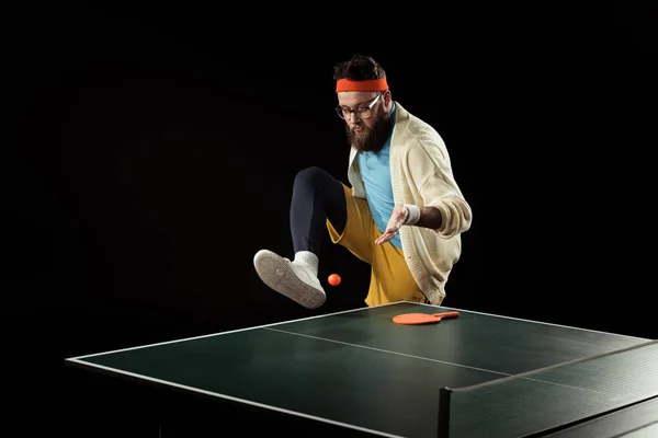 Joueur de tennis barbu jouant avec la balle près de la balle de tennis isolé sur noir — Photo de stock