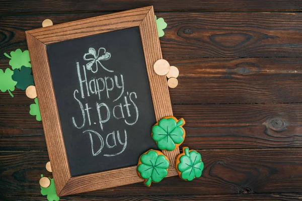 Vue rapprochée du cadre en bois avec inscription joyeuse du jour st patricks et pièces d'or sur la table — Photo de stock