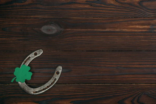 Vue du dessus du fer à cheval et du trèfle vert sur une table en bois — Photo de stock