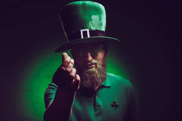 Jeune homme barbu en chapeau vert irlandais et lunettes drôles geste à la caméra — Photo de stock