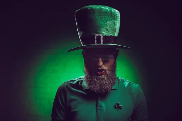 Ritratto di giovane barbuto in cappello verde irlandese e occhiali divertenti — Foto stock