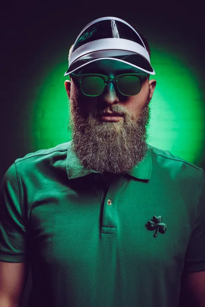 Bonito barbudo homem no verde polo camisa com trevo símbolo — Fotografia de Stock