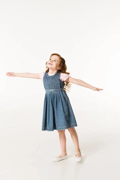 Little stylish kid in dress standing with wide arms isolated on white — Stock Photo