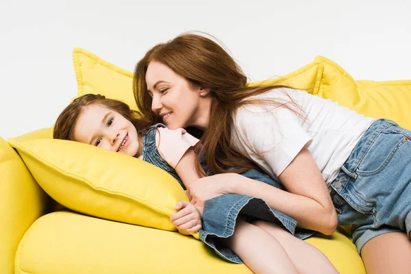 Petit enfant souriant avec mère sur canapé isolé sur blanc — Photo de stock