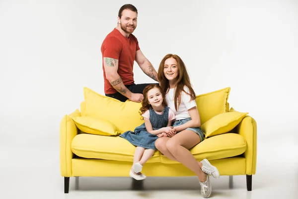 Familia feliz sentado en el sofá aislado en blanco — Stock Photo