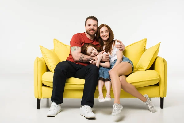 Familia feliz sentado en el sofá aislado en blanco — Stock Photo