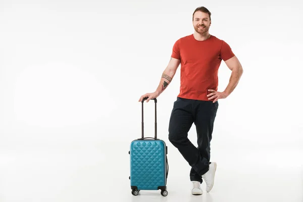 Стильный мужчина, стоящий с чемоданом, изолированным на белом, концепция путешествия — стоковое фото