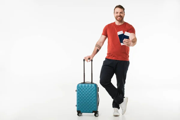 Touriste souriant avec valise, billets et passeports isolés sur blanc, concept de voyage — Photo de stock