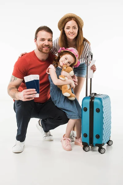 Portrait of happy family of tourists with suitcase isolated on white — Stock Photo