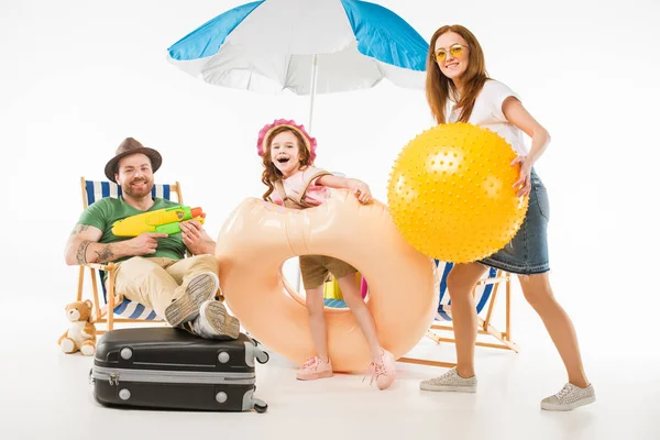 Famiglia con pistola ad acqua, anello di galleggiamento e palla isolata su bianco, concetto di viaggio — Foto stock