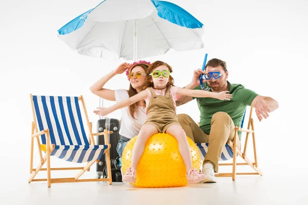 Family in swimming goggles with sunshade, sun loungers and ball isolated on white — Stock Photo