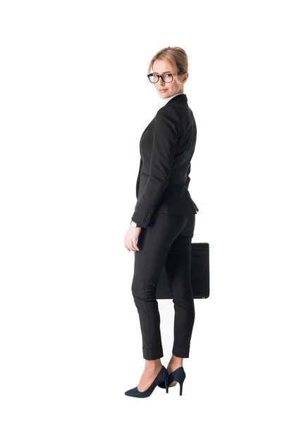Confident businesswoman in black suit holding briefcase isolated on white — Stock Photo