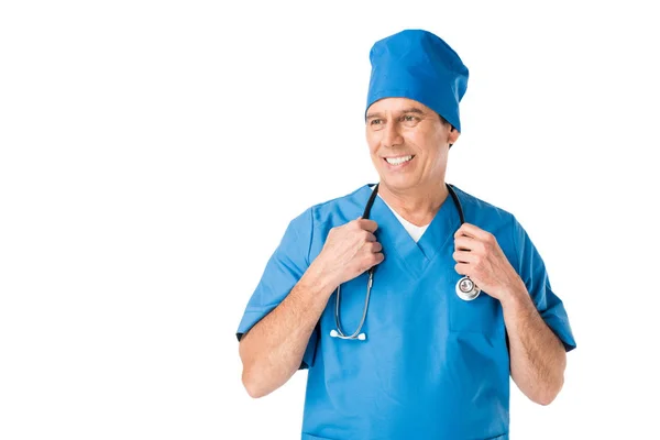 Улыбающийся доктор в форме держит стетоскоп изолированным на белом — стоковое фото