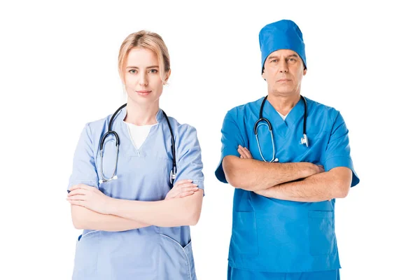 Enfermeira equipe médica e médico de uniforme com estetoscópios de pé com os braços dobrados isolados em branco — Fotografia de Stock